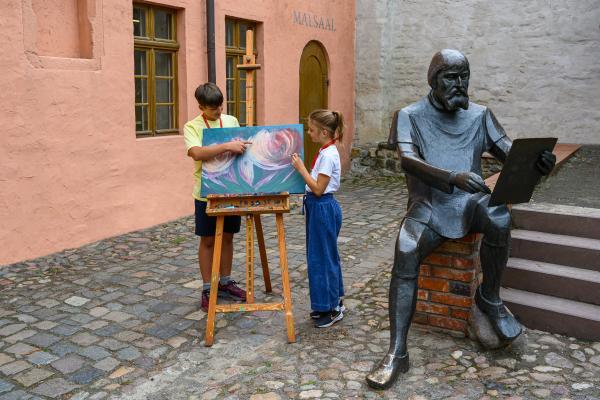 Uwe Weigel Kinder an der Cranach-Skulptur im Cranach-Hof